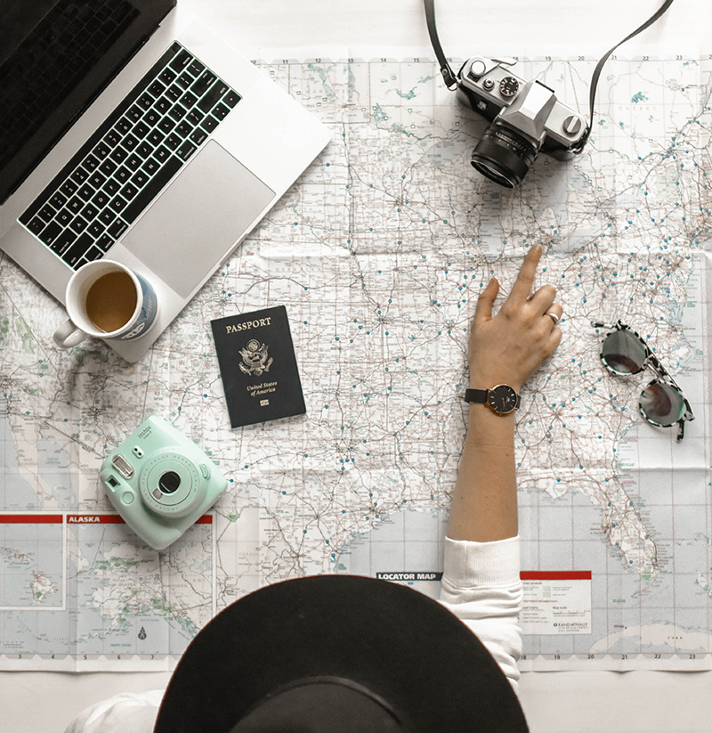 Traveler with map, computer, camera, passport